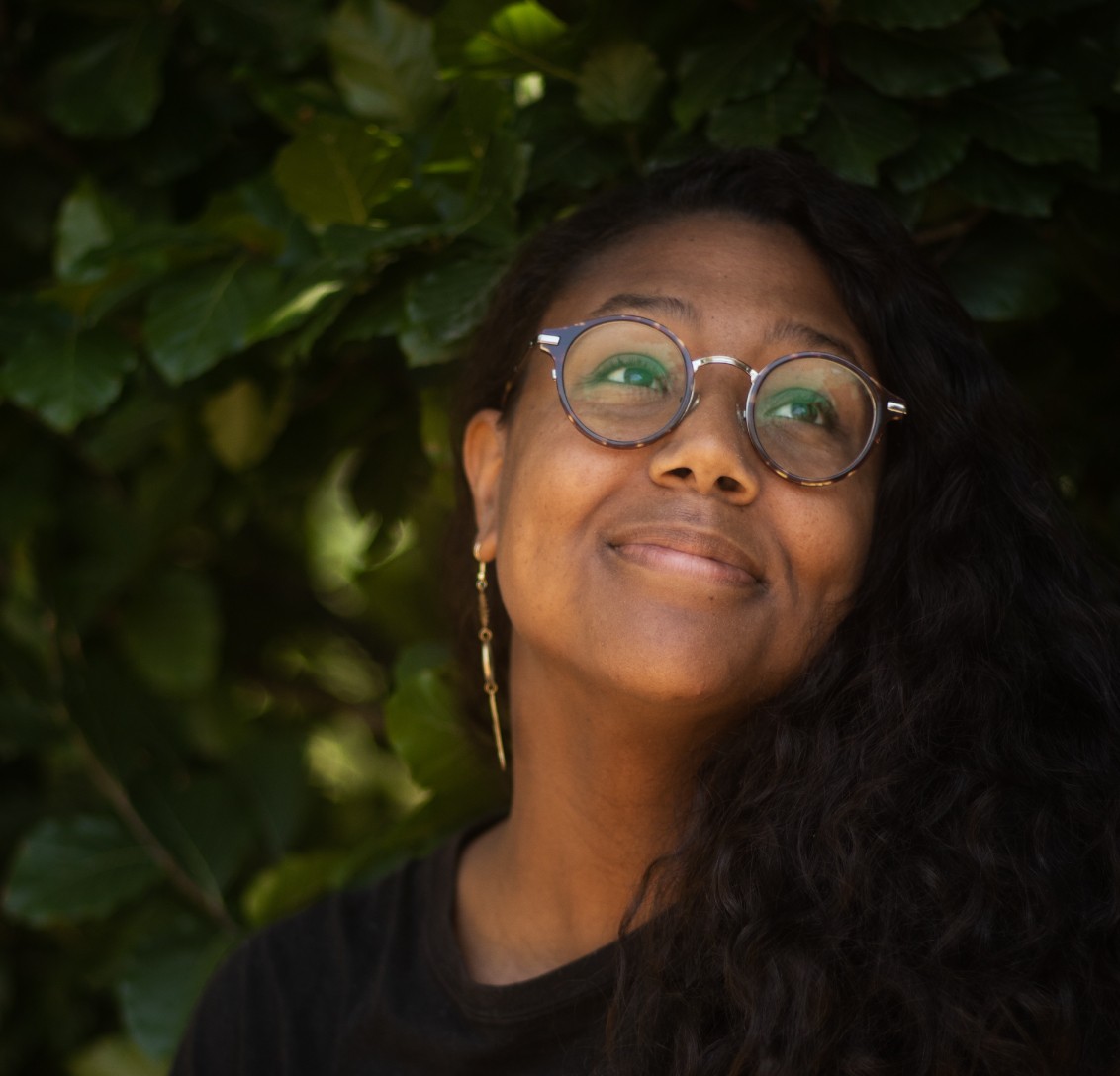 Desirée looks up and to the right with a slight smile.